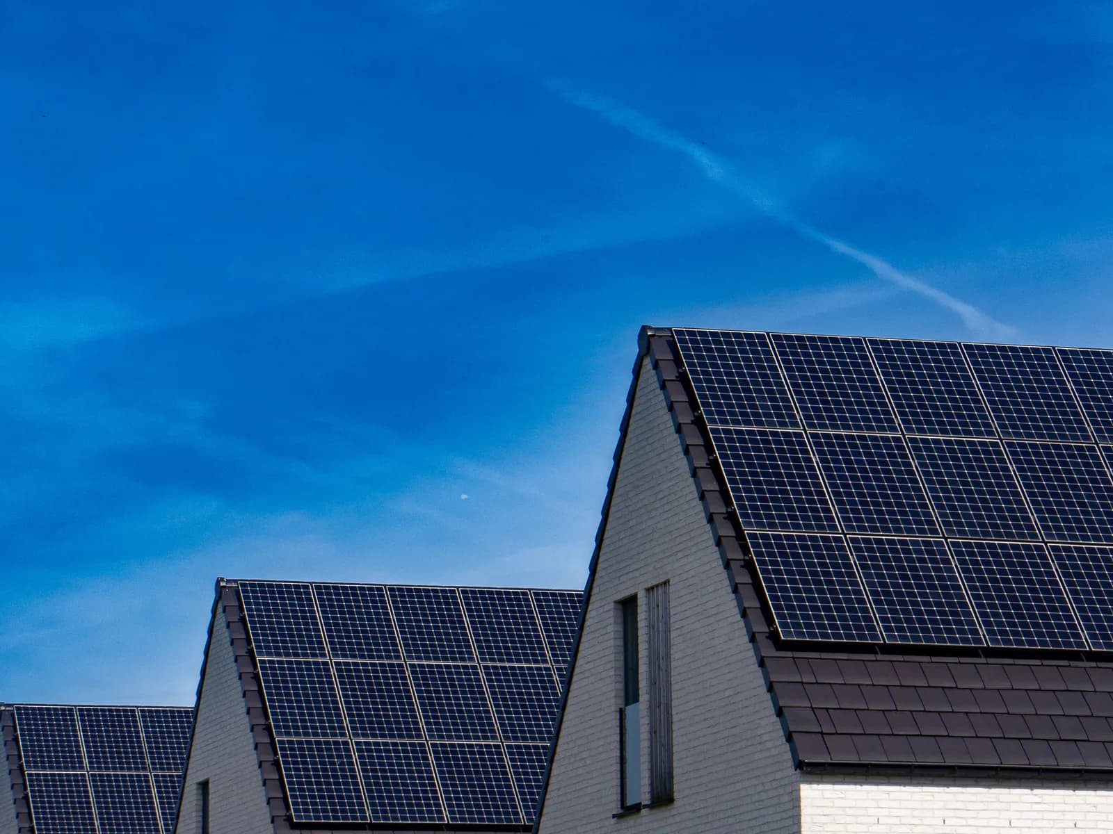 Drei benachbarte Häuser, auf jedem Dach eine eigene Solaranlage